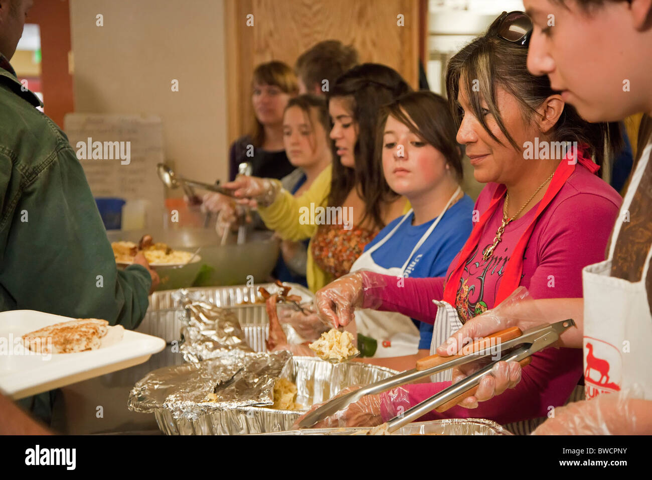 Freiwillige dienen Mahlzeit im Obdachlosenheim Stockfoto