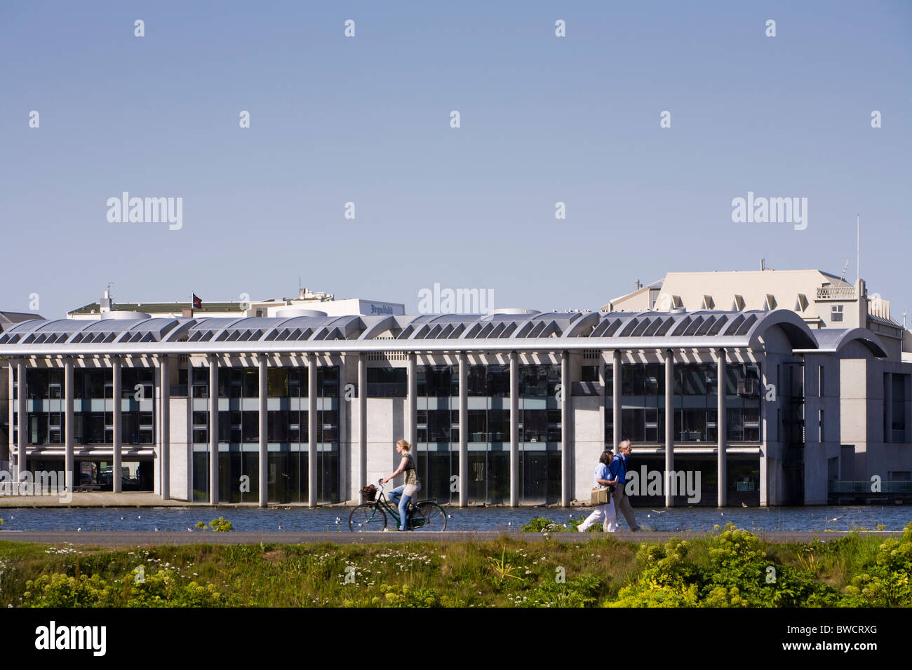 Menschen wandern und Radfahren Tjörnin See, Rathaus von Reykjavik im Hintergrund. Reykjavik Island Stockfoto