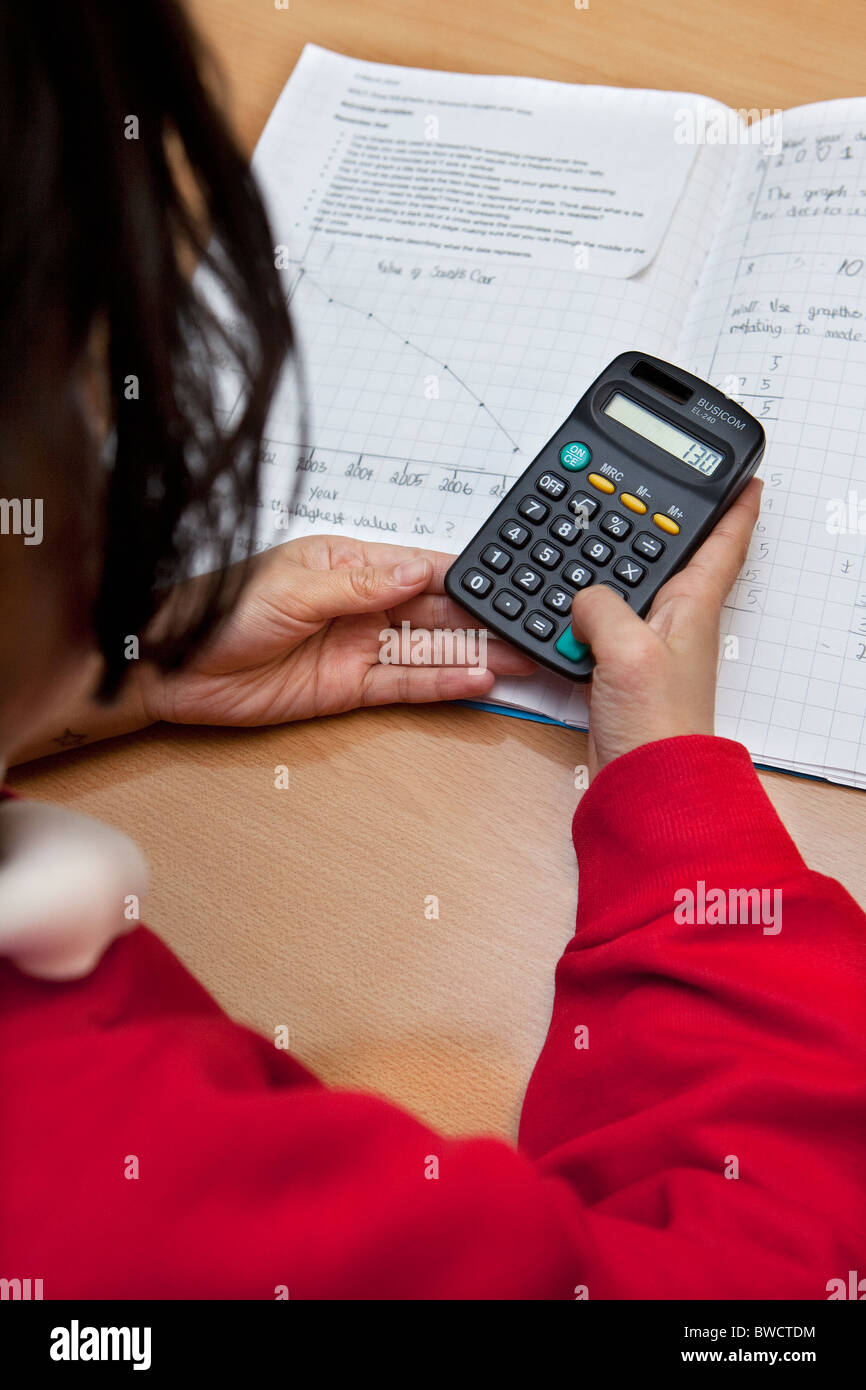 Kind mit einem Taschenrechner in Mathematik Schulstunde Stockfoto