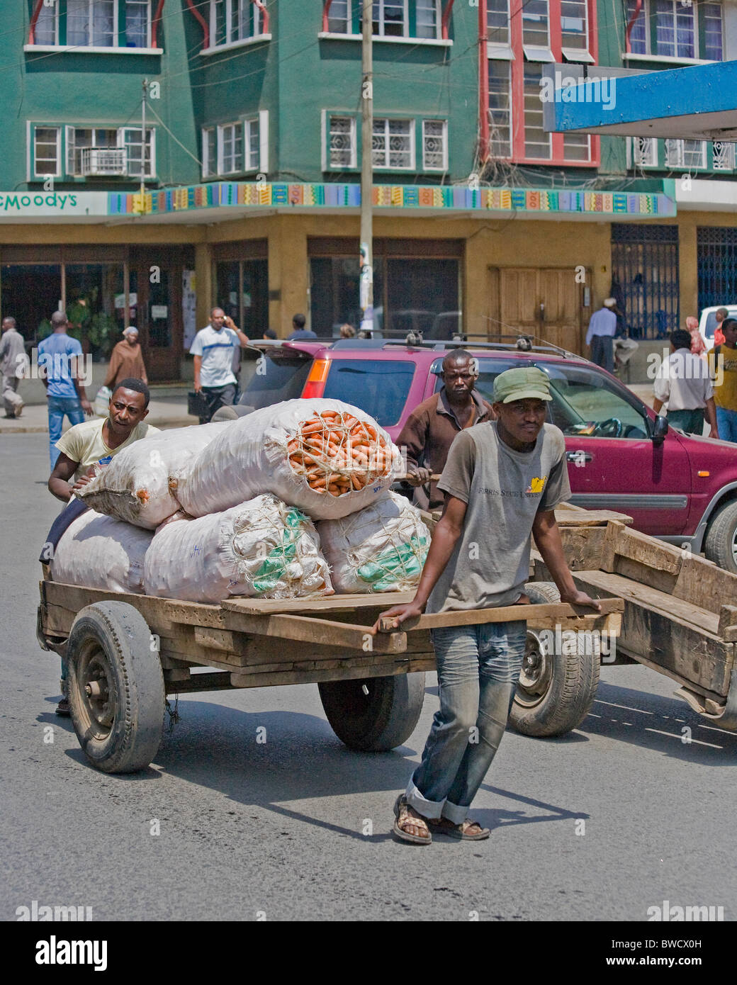 Einheimische nehmen ihre Produkte auf den Markt inmitten der bunten Straßen von Arusha, Tansania. Stockfoto