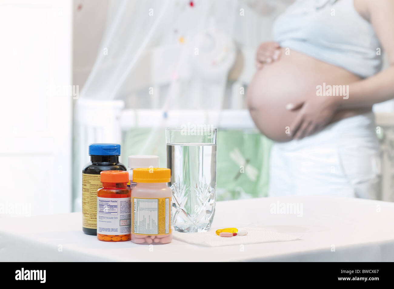 Pränatale Vitamine Mutter Bauch Kindergarten gesundes Baby halten Stockfoto