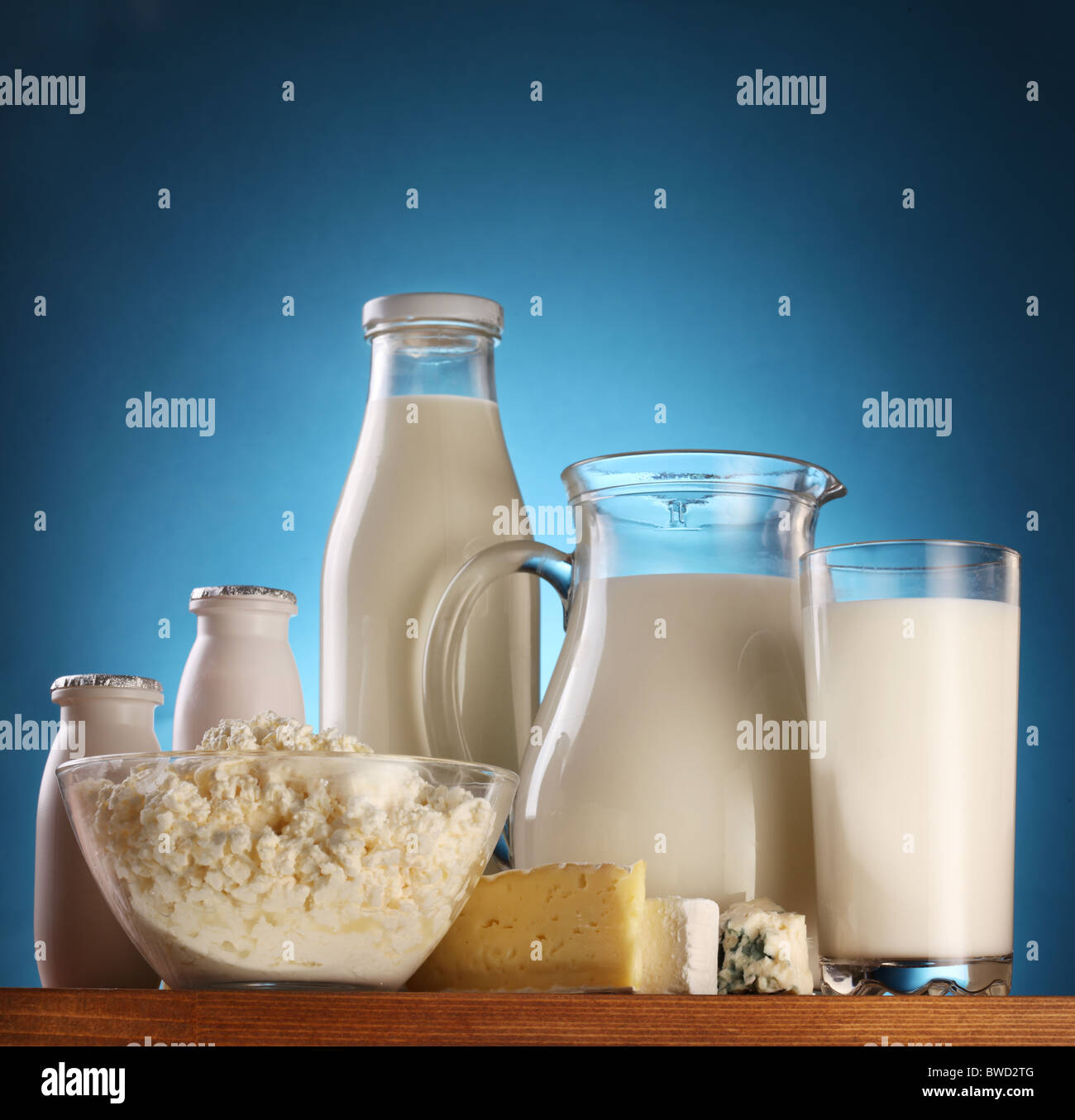 Verschiedene Milchprodukte: Käse; Creme; Milch. Auf einem blauen Hintergrund. Stockfoto