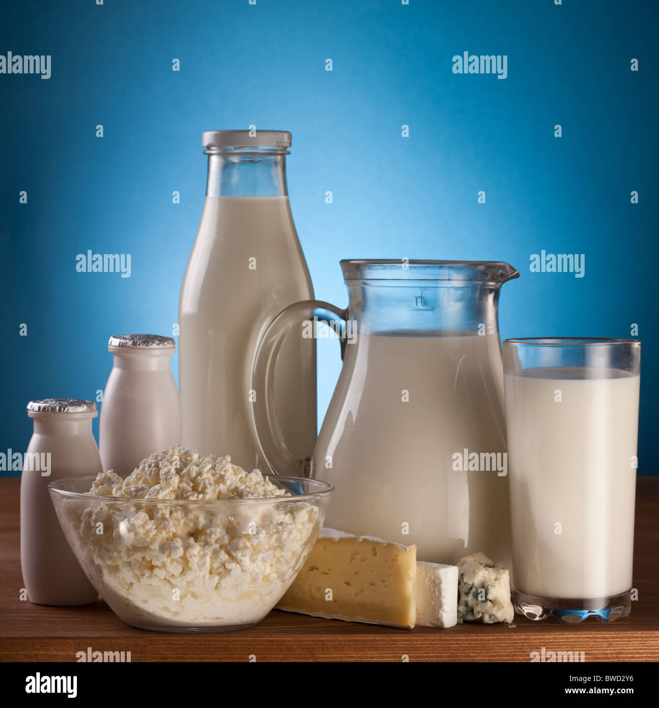Verschiedene Milchprodukte: Käse; Creme; Milch. Auf einem blauen ...