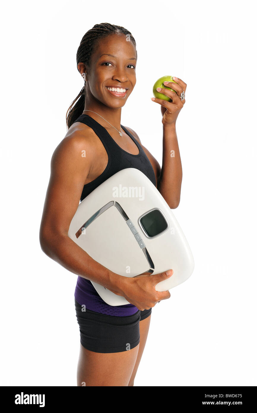 Young African American Frau mit Waage und Apfel isoliert auf weißem Hintergrund Stockfoto