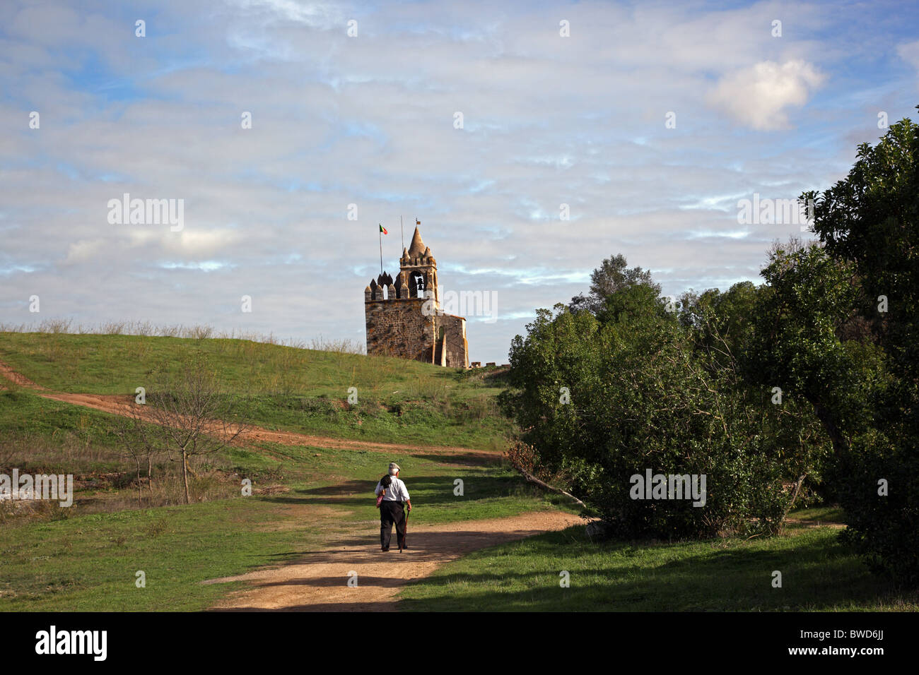 Ein portugiesischer Landwirt zu Fuß in Richtung des Glockenturms auf der Burg Ruinen Montemor-o-Novo Alentejo Region Portugal Europa Stockfoto