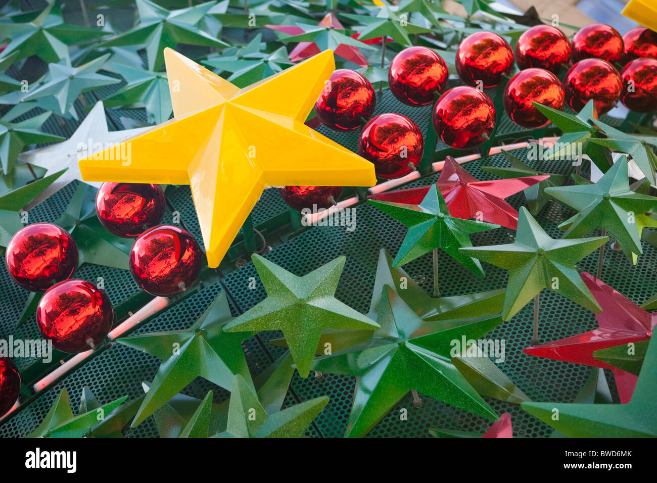 Moderne Metall und Kunststoff Weihnachtsbaum in Melbourne, Australien mit roten Kugeln, grüne Sterne und große leuchtend gelben Stern Stockfoto