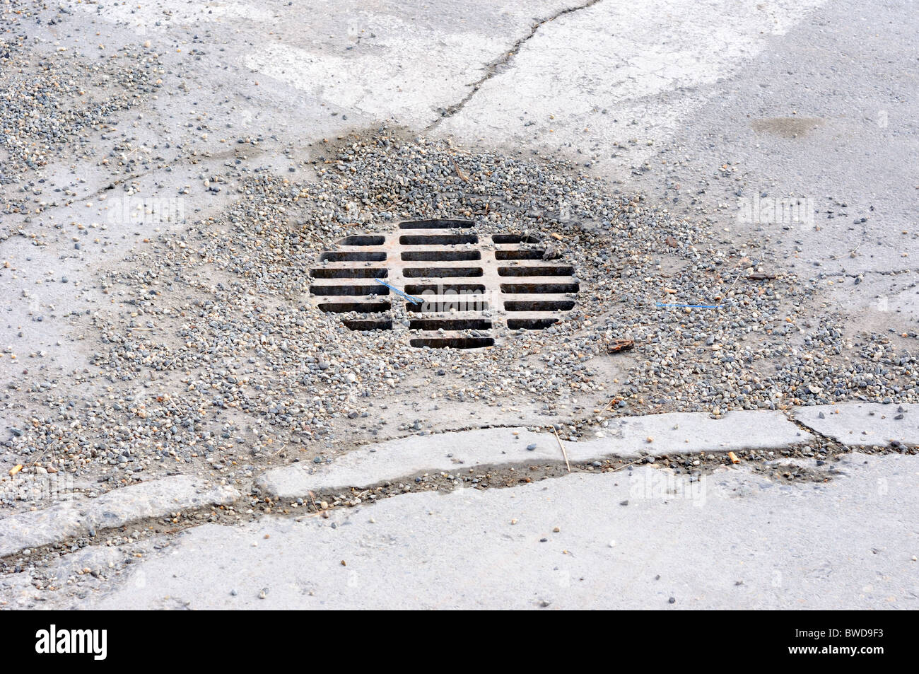 Kies bedeckt Sturm abtropfen lassen, in einem städtischen Fahrbahn Stockfoto