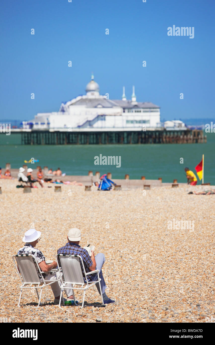 Zwei Menschen sitzen auf Stühlen am Strand; Eastbourne; East Sussex; England, Großbritannien Stockfoto