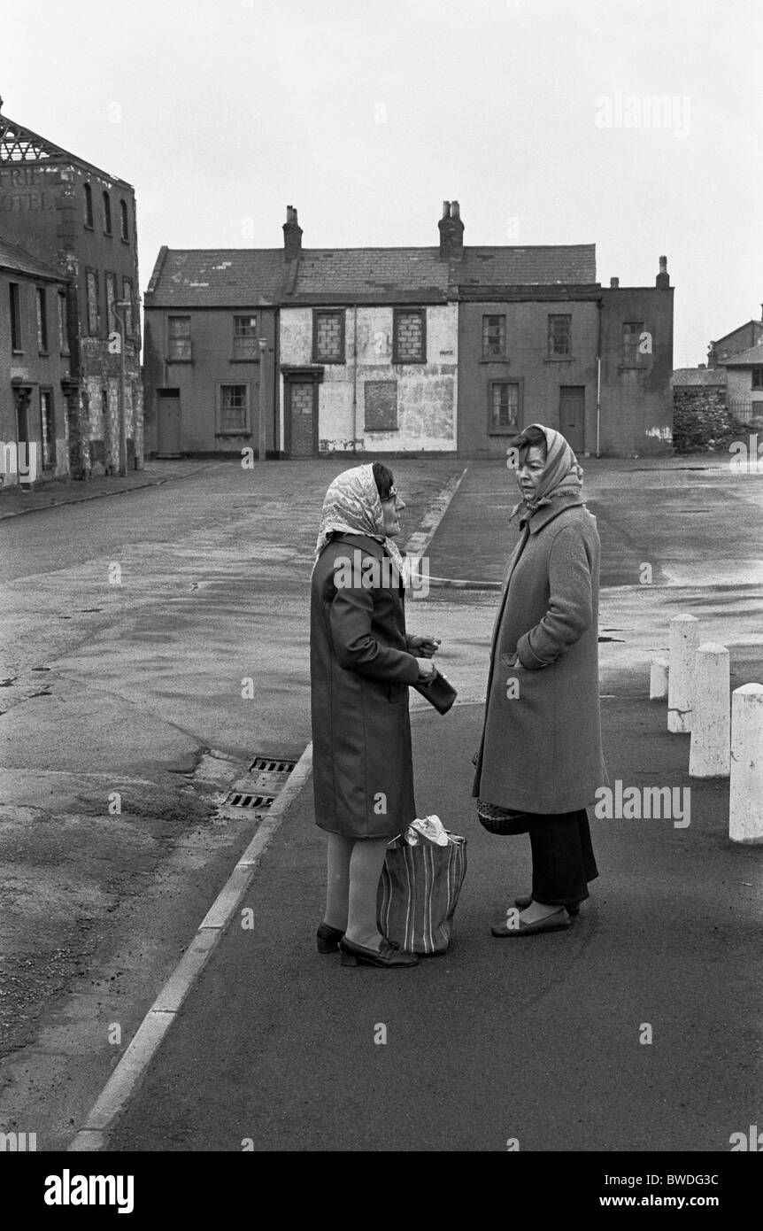 Frauen im Chat in einer Straße mit Brettern vernagelt Häuser Abriss, in Erwartung Butetown (Tiger Bay), Cardiff, Wales, 1974 Stockfoto