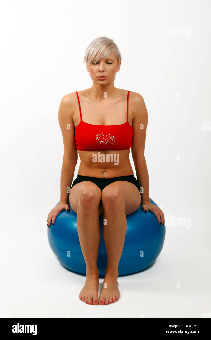 junge Frau mit einem Schweizer Gymnastikball und benutzen, um ihre Rumpfmuskulatur verbessern Stockfoto