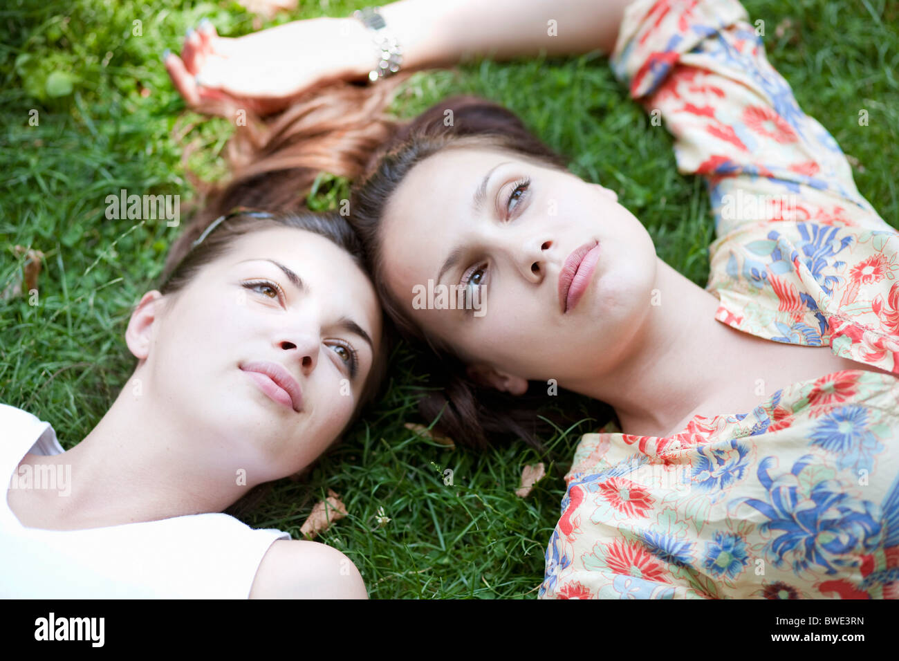 Junge Frauen im Grass liegen Stockfoto