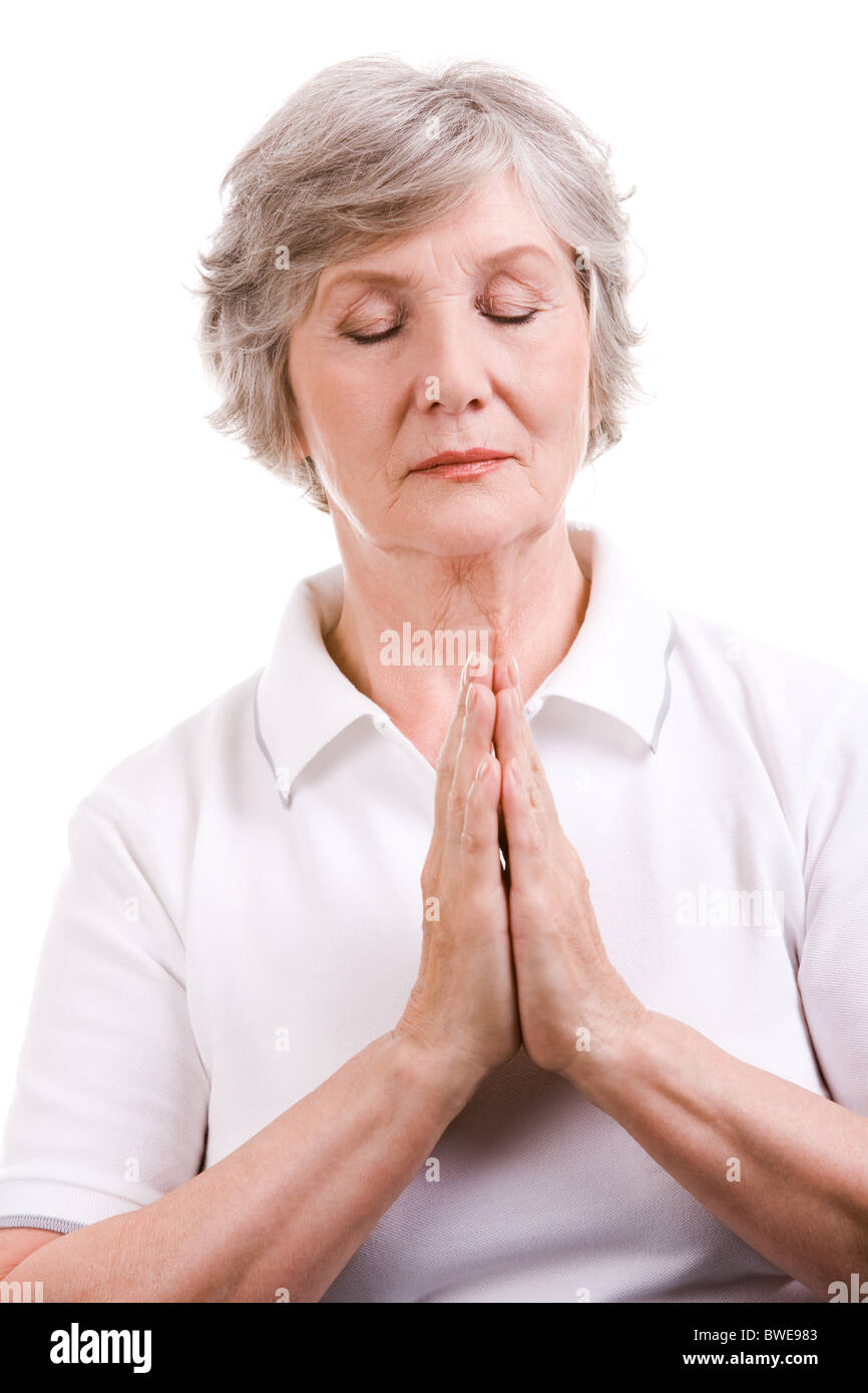Porträt von Reife Frau beten mit den Händen zusammen und die Augen schließen Stockfoto
