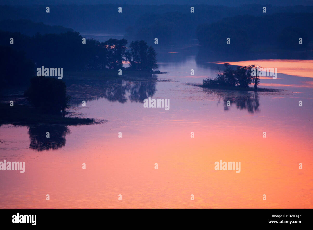 Rosa Abendlicht spiegelt sich in den ruhigen Gewässern des Mississippi River in der Nähe von Savanne, IL. Stockfoto