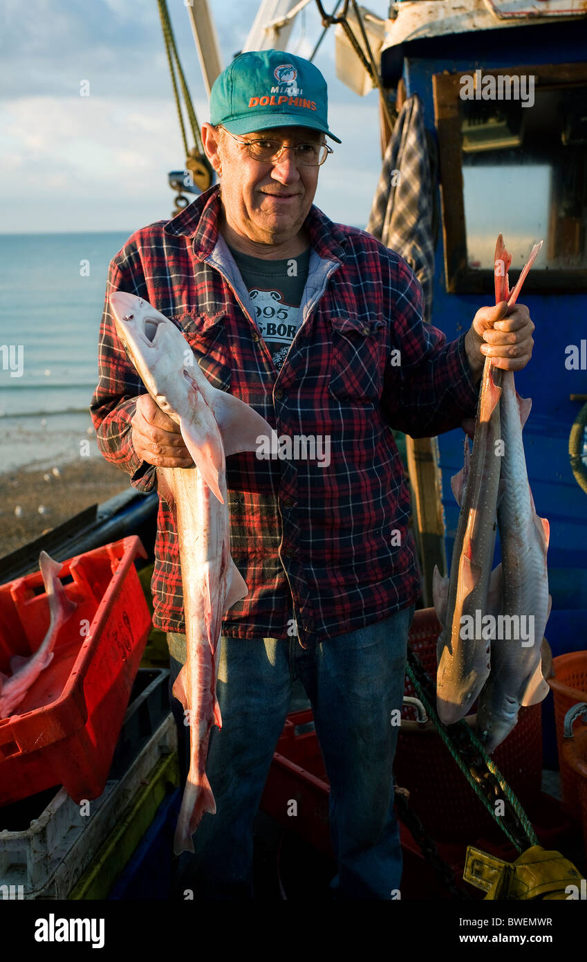 Harte Arbeit Fischer kommen mit ihrer Nacht Fang im Morgengrauen in ihrem Boot auf Strand an Hastings alte Stadt East Sussex. Stockfoto