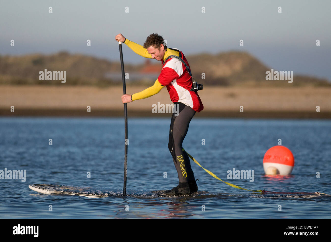 männliche Surfer Paddeln auf Surfbrett, Blakeney, North Norfolk, england Stockfoto