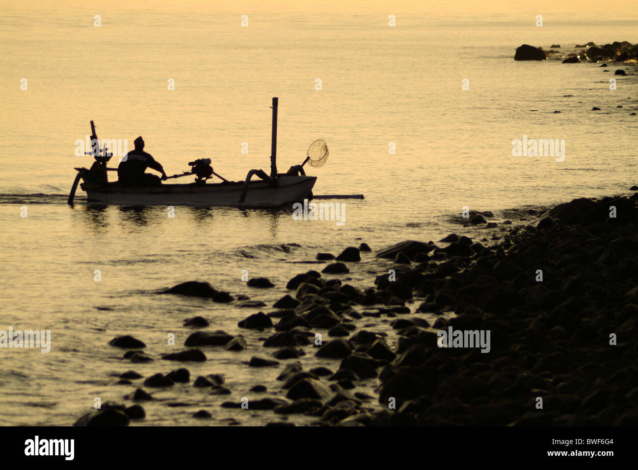 Im Dorf Tejakula, Bali, die Fischer kommen ans Ufer bei Sonnenaufgang, ihren Fang entladen. Familie kommt mit der Arbeit zu helfen. Stockfoto