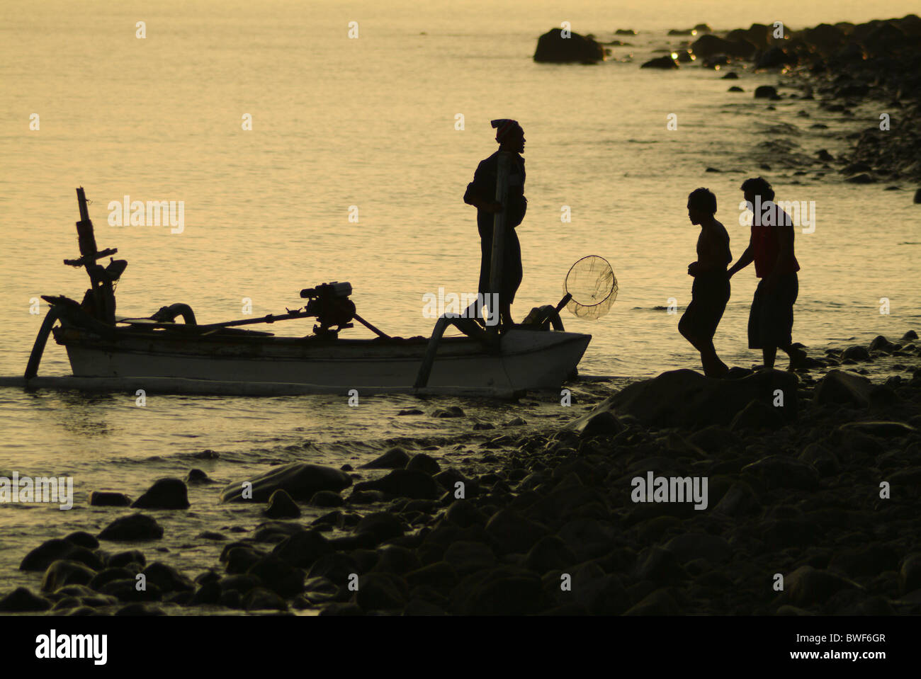 Im Dorf Tejakula, Bali, die Fischer kommen ans Ufer bei Sonnenaufgang, ihren Fang entladen. Familie kommt mit der Arbeit zu helfen. Stockfoto