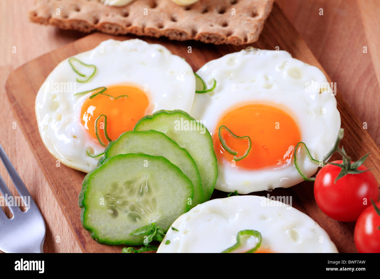 Frühstück - Fried Eiern, knuspriges Brot und frisches Gemüse Stockfoto