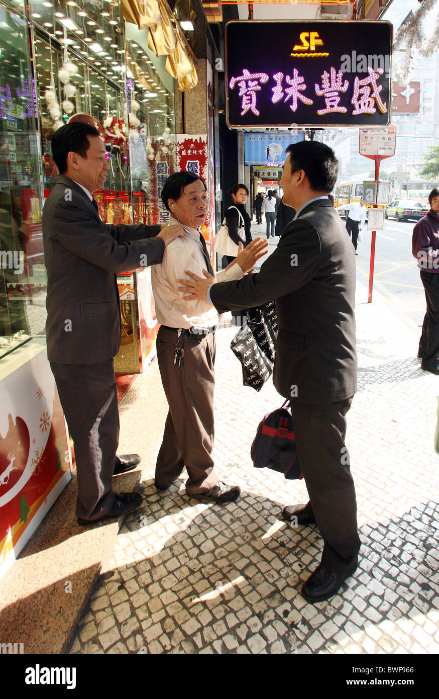 Männer sprechen in einer Straße, Macao, China Stockfoto