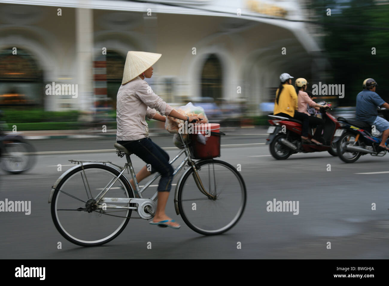 Radfahren auf Straße Hanoi mit traditionellen vietnamesischen Hut Frau Stockfoto