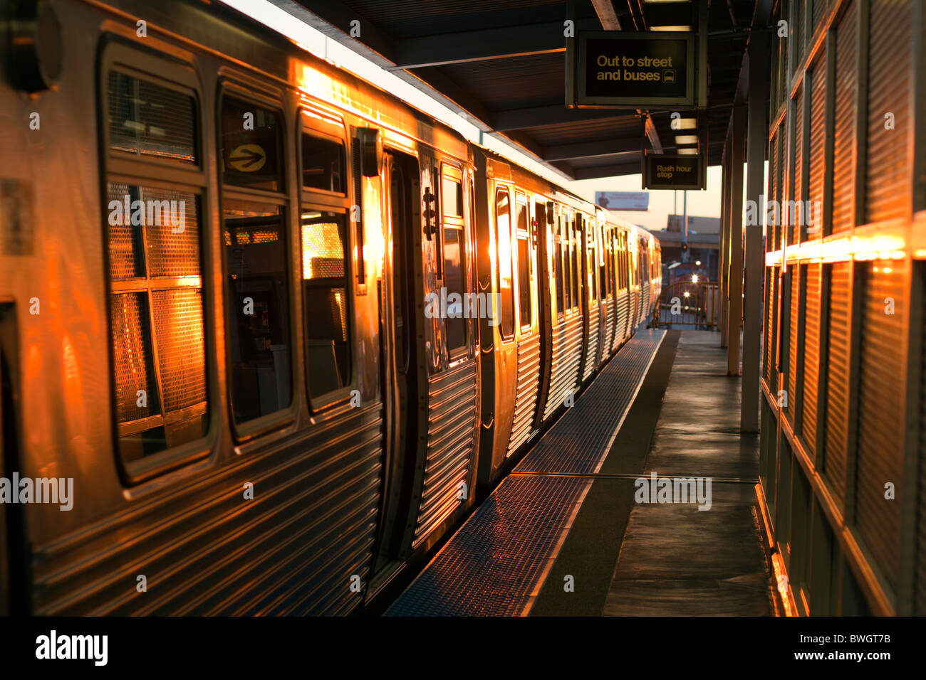 In das goldene Licht in der Nähe von Sonnenuntergang hält ein Chicago L Zug an Ashland auf der Orange Linie. Stockfoto