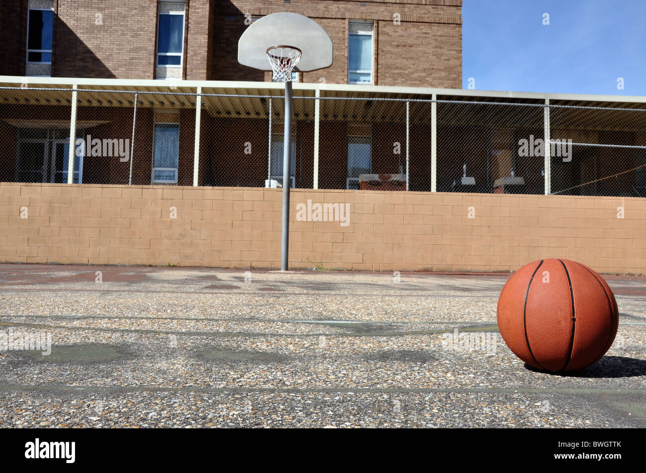 Basketball am Gericht am Schulhof mit Ziel im Hintergrund. Stockfoto