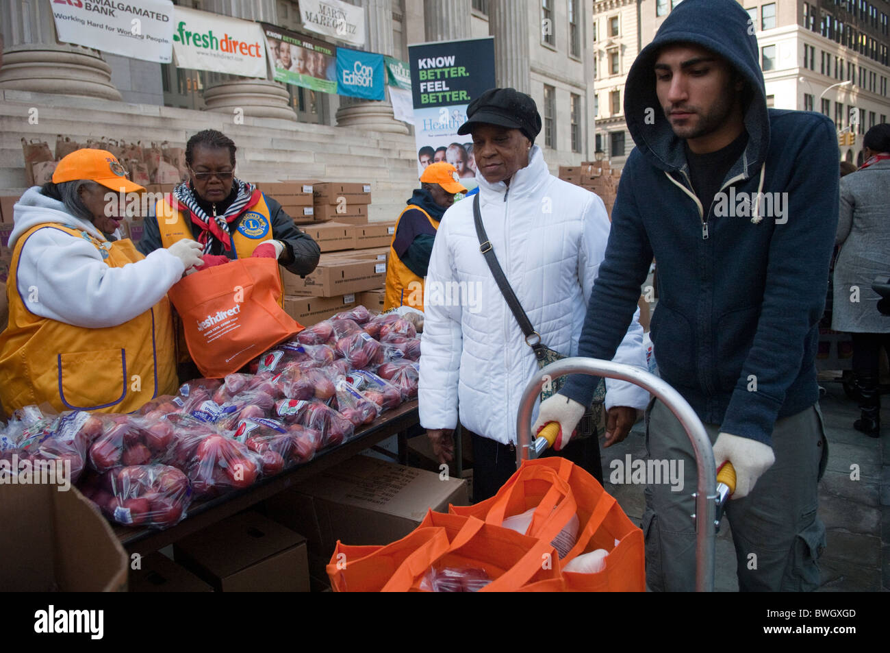 Freiwillige Helfer bereiten Körbe mit gefrorene Truthähne und andere Urlaub Lebensmittel außerhalb Brooklyn Borough Hall in New York Stockfoto