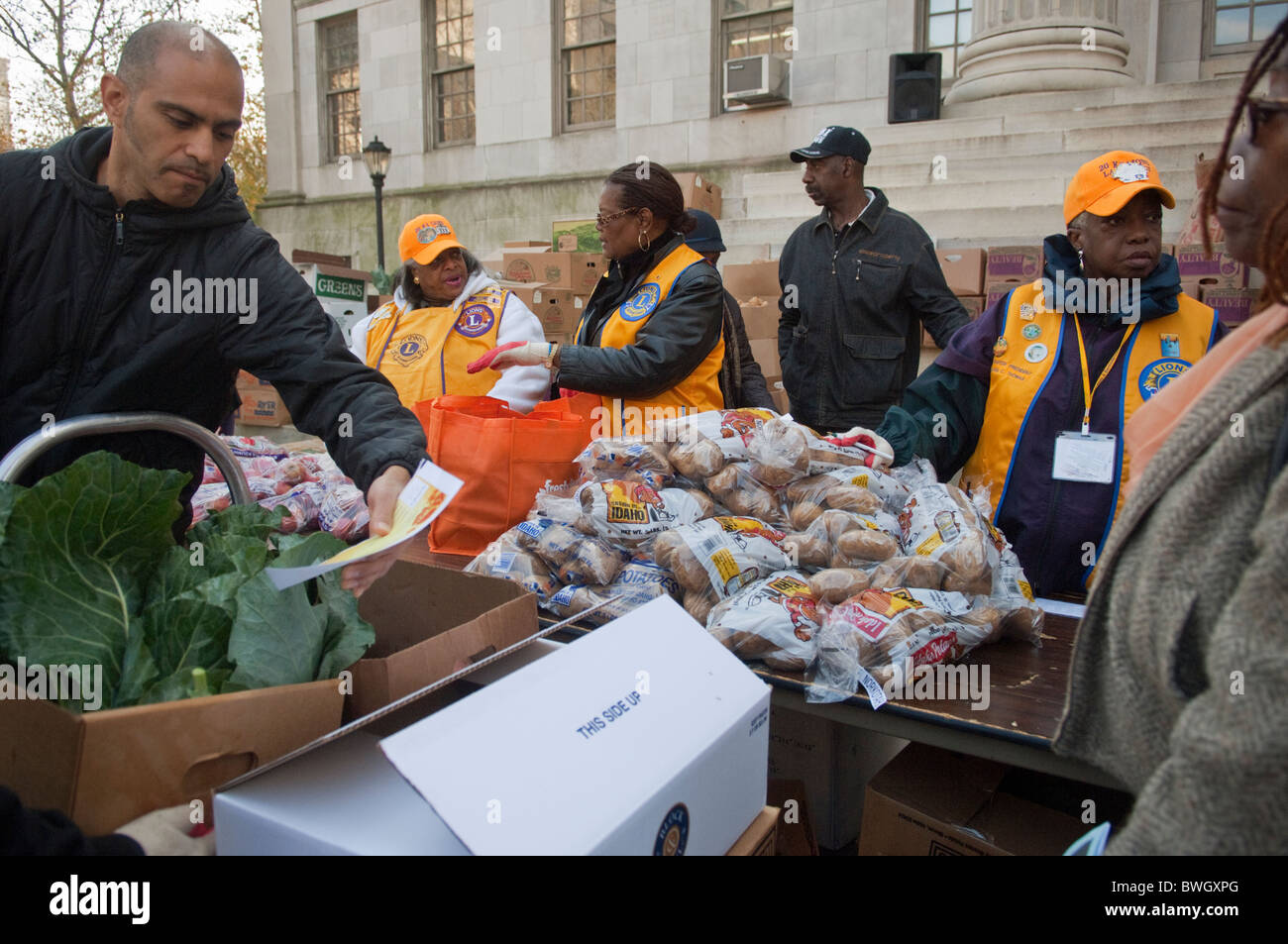 Freiwillige Helfer bereiten Körbe mit gefrorene Truthähne und andere Urlaub Lebensmittel außerhalb Brooklyn Borough Hall in New York Stockfoto