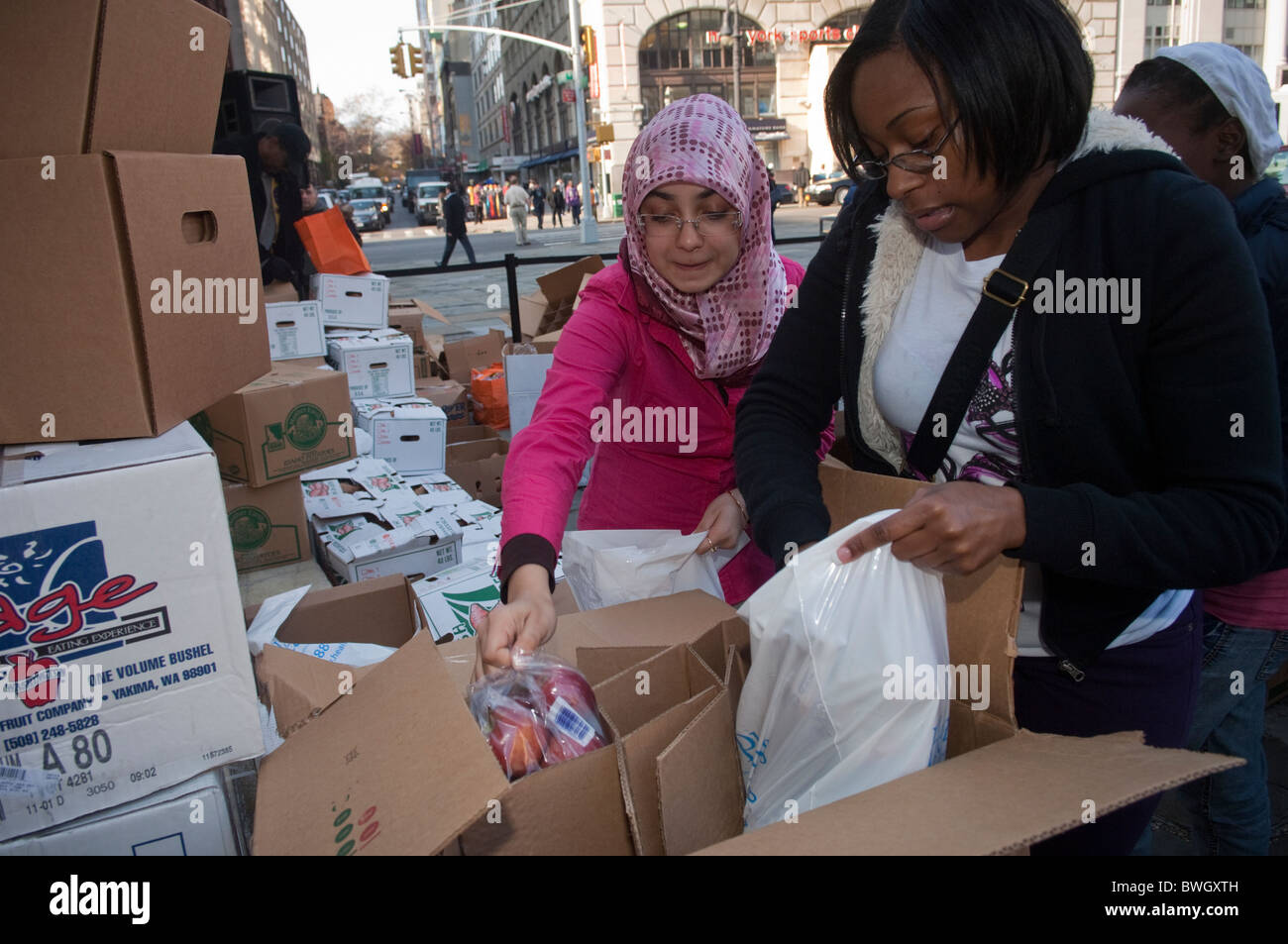 Freiwillige Helfer bereiten Körbe mit gefrorene Truthähne und andere Urlaub Lebensmittel außerhalb Brooklyn Borough Hall in New York Stockfoto