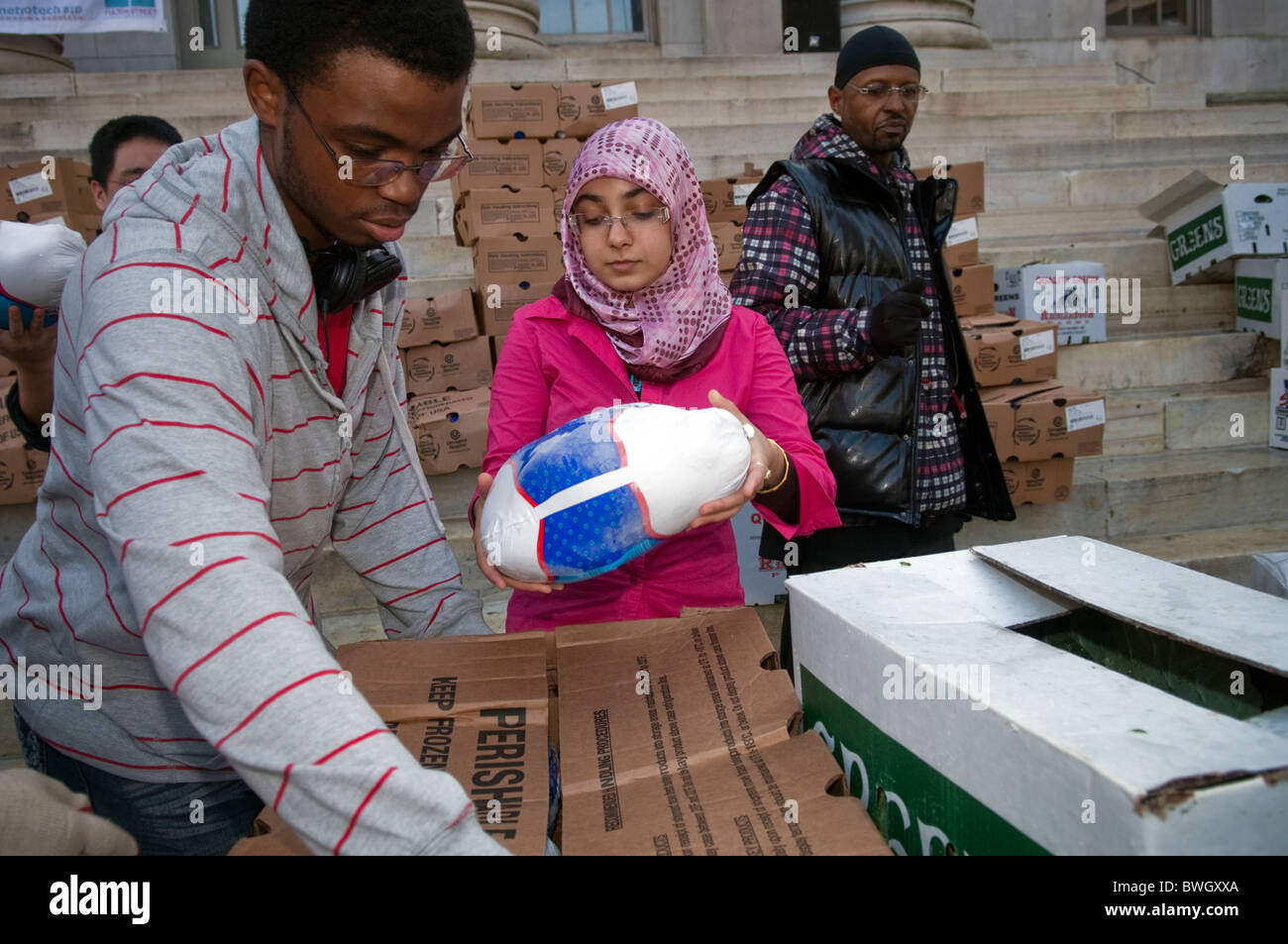 Freiwillige Helfer bereiten Körbe mit gefrorene Truthähne und andere Urlaub Lebensmittel außerhalb Brooklyn Borough Hall in New York Stockfoto