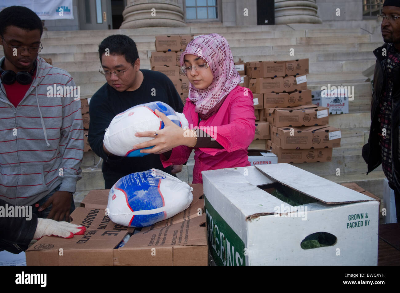 Freiwillige Helfer bereiten Körbe mit gefrorene Truthähne und andere Urlaub Lebensmittel außerhalb Brooklyn Borough Hall in New York Stockfoto