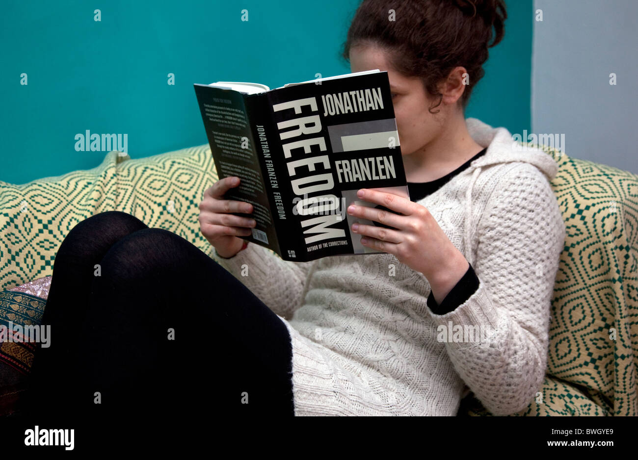 Junge Frau liest Roman zu Hause, London: Modell veröffentlicht Stockfoto