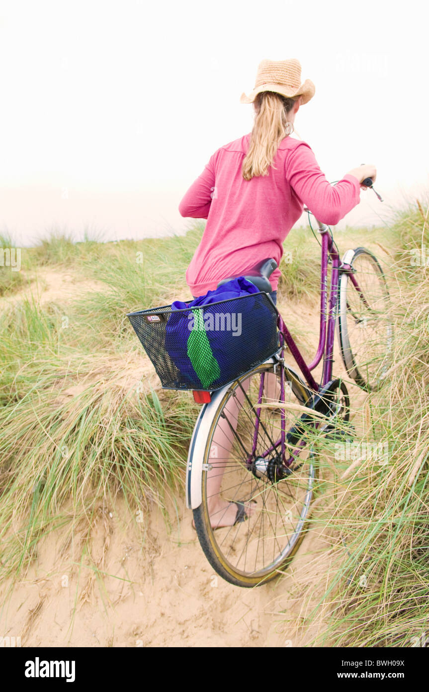 Frauen schiebt Fahrrad über Strand Stockfoto