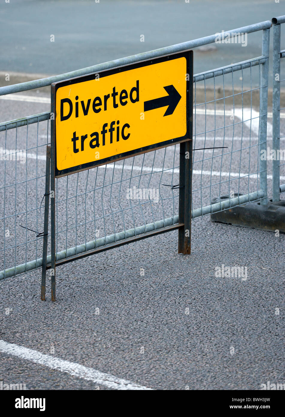 Transportieren Sie Straße Zeichen gelb umgeleitet Abzweigung Verkehrszeichen auf Barriere über leere städtische Straße in Bognor Regis. Stockfoto
