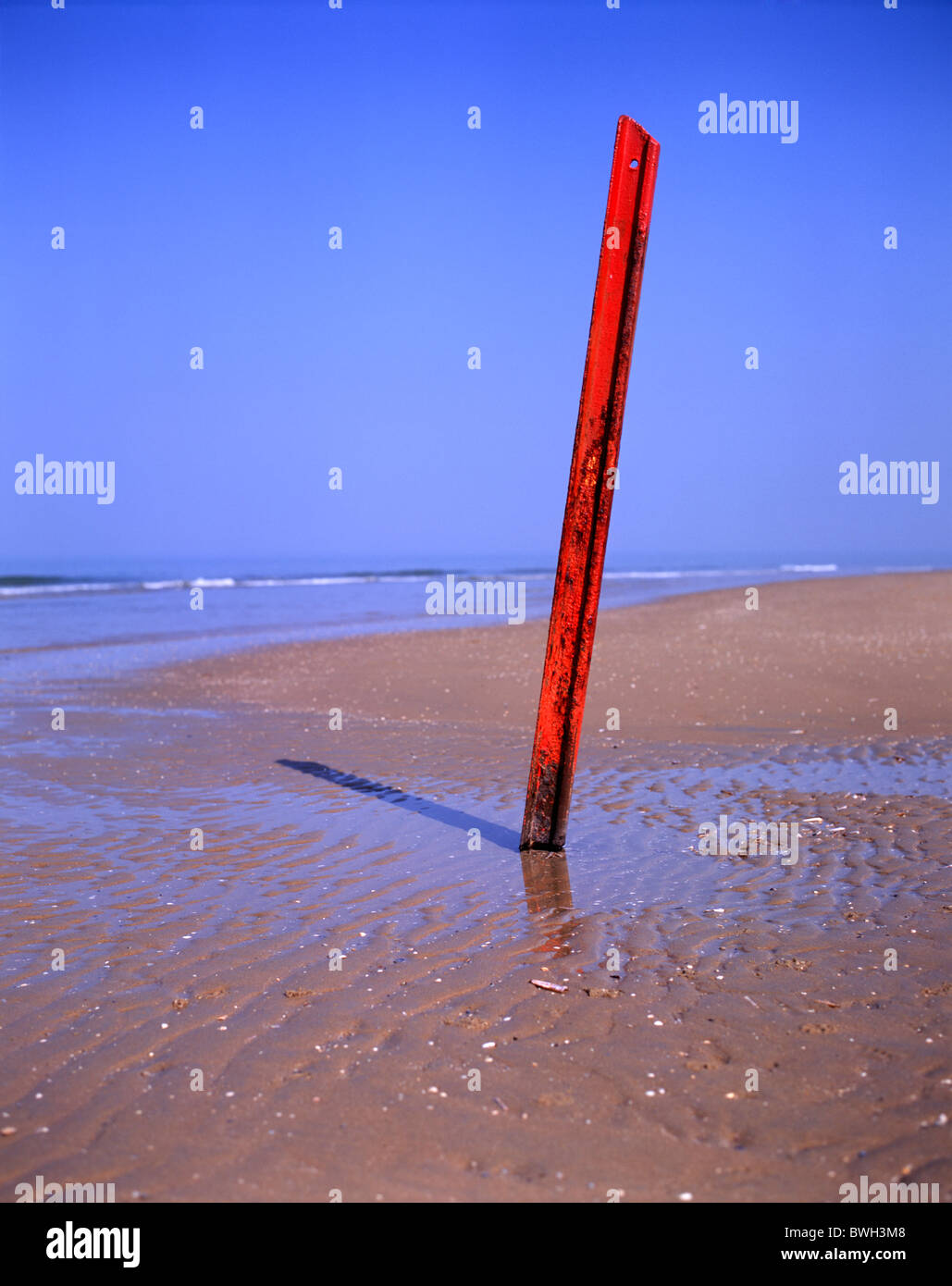 #1 von 3: vertikale rote Bahntrasse ragte aus dem sandigen Strand in Scheveningen, den Haag, NL Stockfoto
