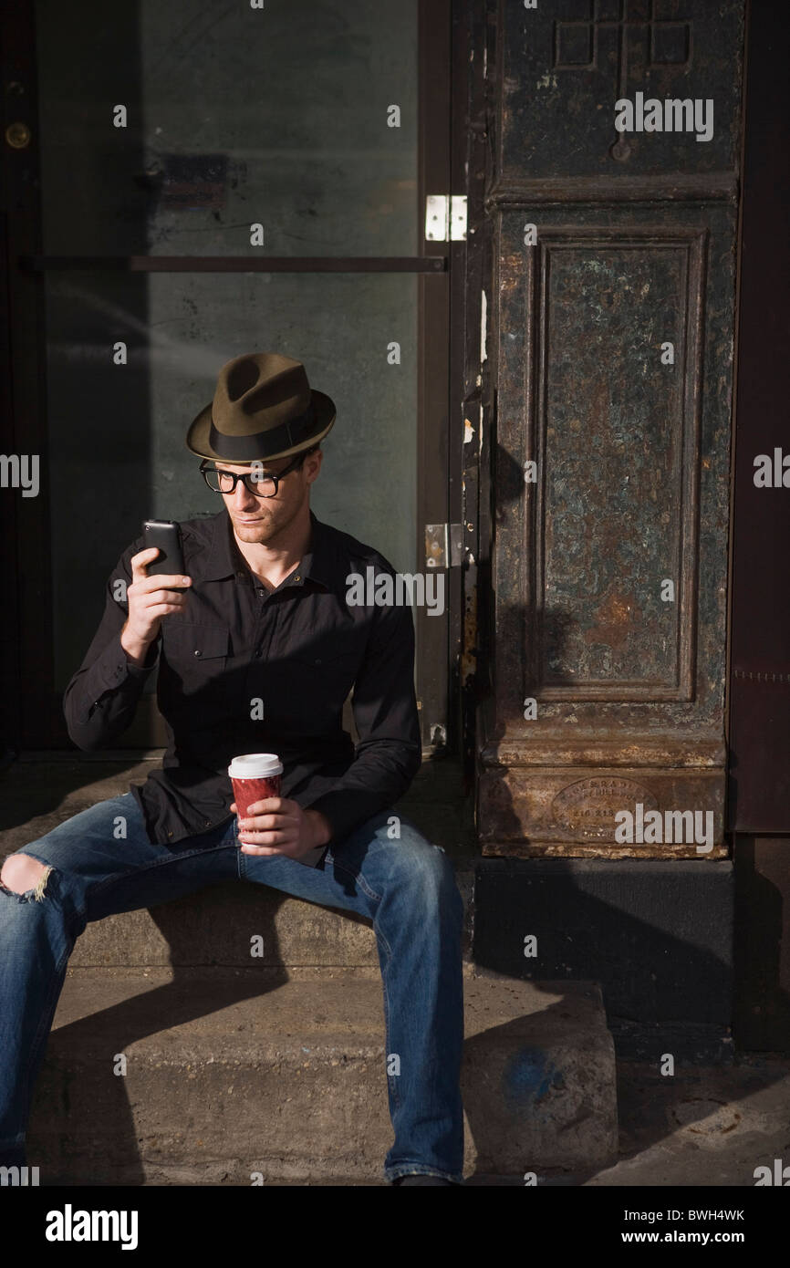 Mann mit Kaffee und ein Handy Stockfoto