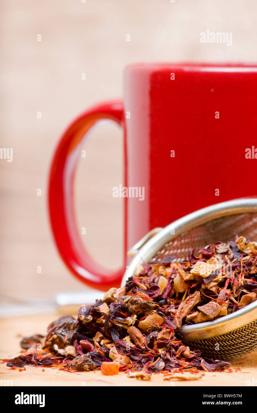 Getrocknete Früchte-Tee im Teesieb mit Tasse Tee Stockfoto