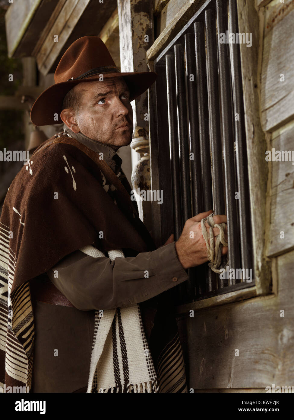 Führerschein und Fingerabdrücke bei MaximImages.com - Cowboy steht nachts vor einer Tür vor einem Bankgebäude. Wilder Westen, ein berüchtigter Kriminalräuber Stockfoto