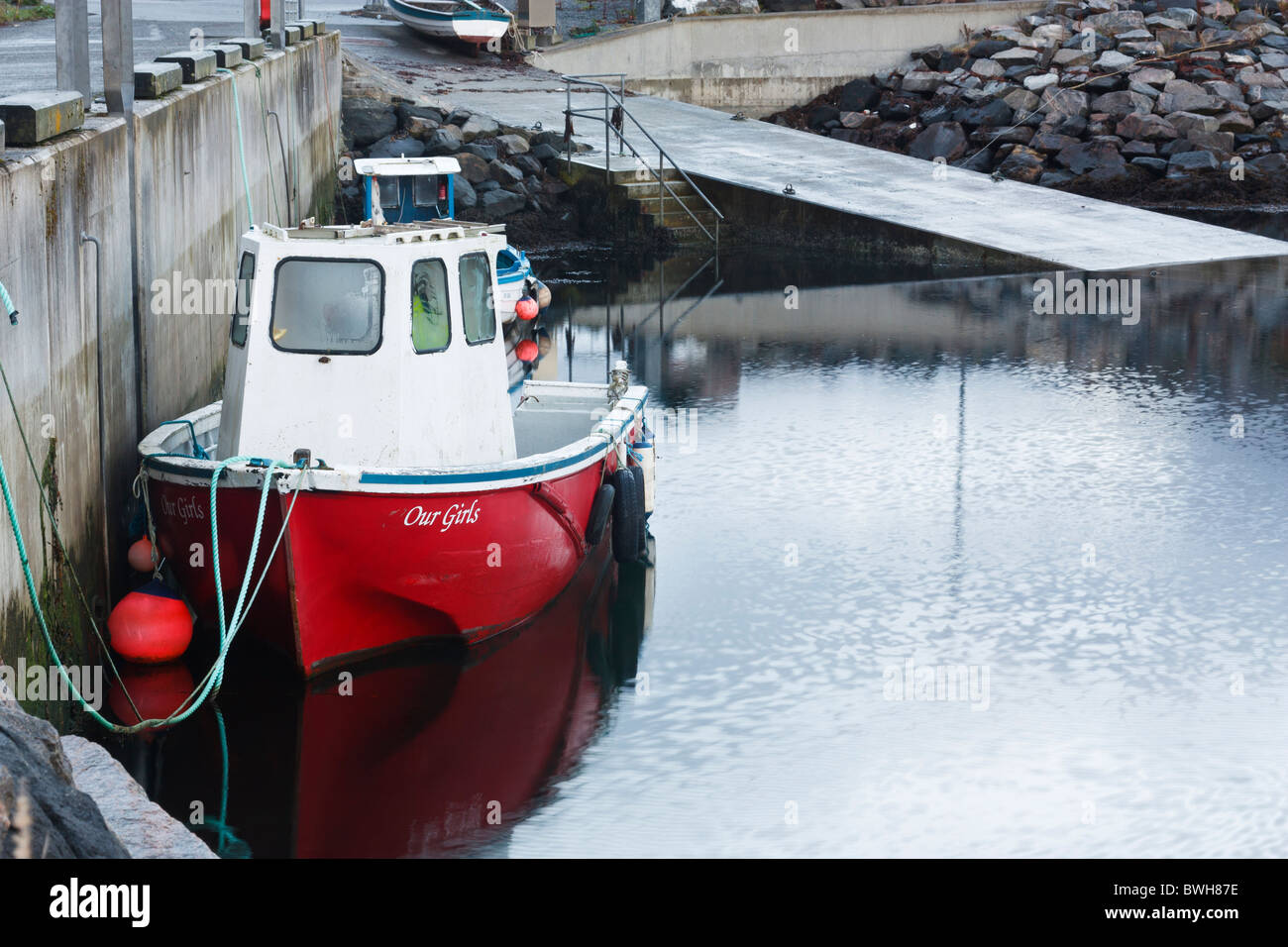 Kleine rote und weiße Fischerboot etwa in See stechen von Tarbert Hafen, Insel Harris, Schottland Stockfoto