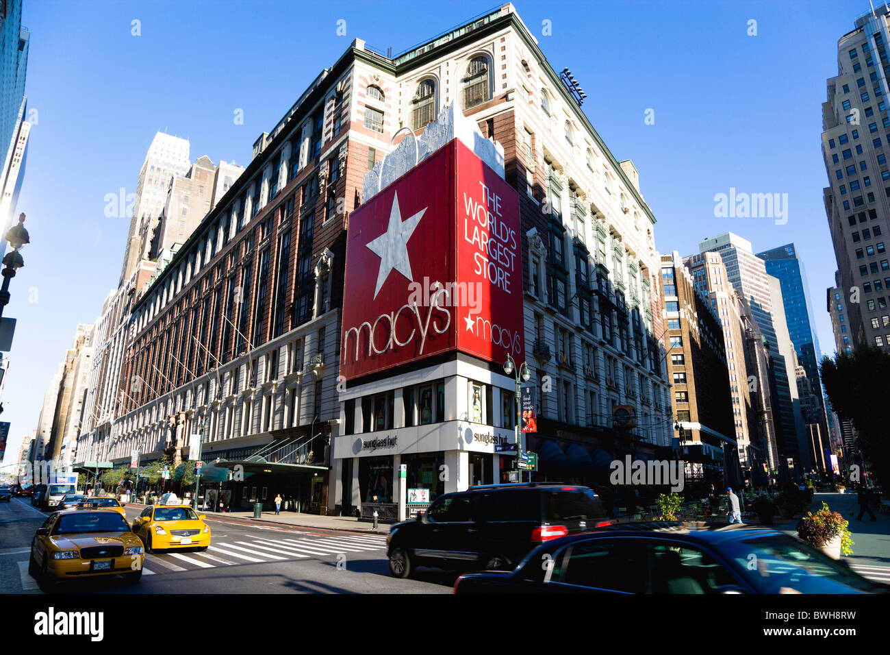 USA New York NYC Manhattan Macys Kaufhaus mit Autos an der 34th Street und Passanten in der Fußgängerzone Broadway. Stockfoto