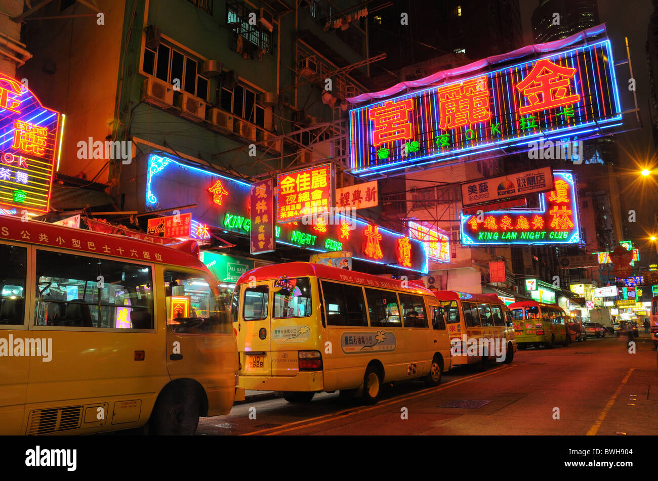 Busse auf einer belebten Straße der Hong Kong bei Nacht Stockfoto