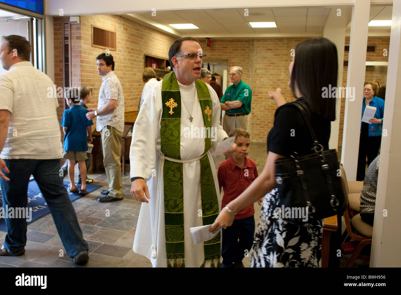 Anglo männlichen Pastor bereitet sich auf weibliche Mitglied der Kirche nach dem sonntäglichen Gottesdienst in der lutherischen Kirche in Austin zur Begrüßung umarmen Stockfoto
