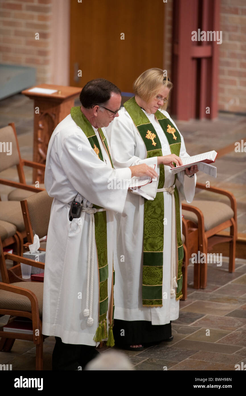 Anglo männliche Vorsitzende Minister und Anglo weibliche Unterstützung betrachten ihre Gebetbücher im sonntäglichen Gottesdienst Stockfoto