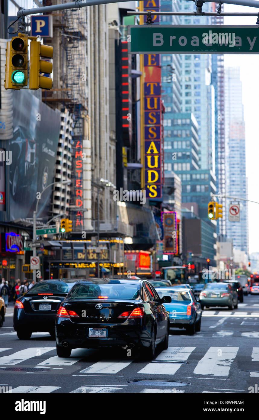 USA, New York, Manhattan, Cars crossing Broadway at green traffic lights travelling east along 42nd Street in Theatre District Stockfoto