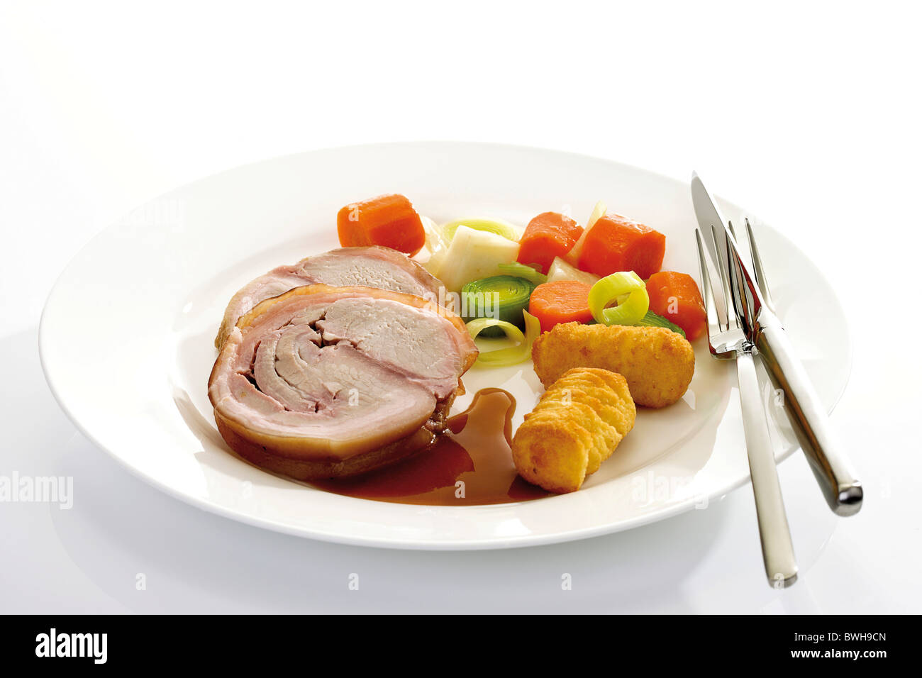 Spanferkel braten gerollt, Schweinefleisch gerollt, Braten, Sauce, Gemüse, Kartoffelkroketten Stockfoto