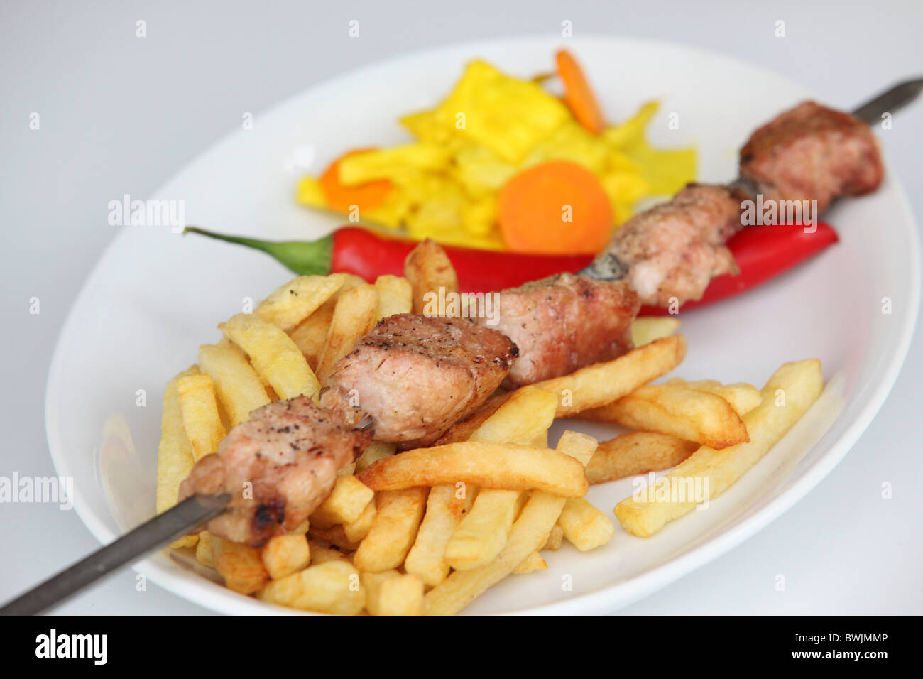 Saibling vom Grill Türkei Schaschlik-Spieß mit Pommes Frites und Chili Stockfoto