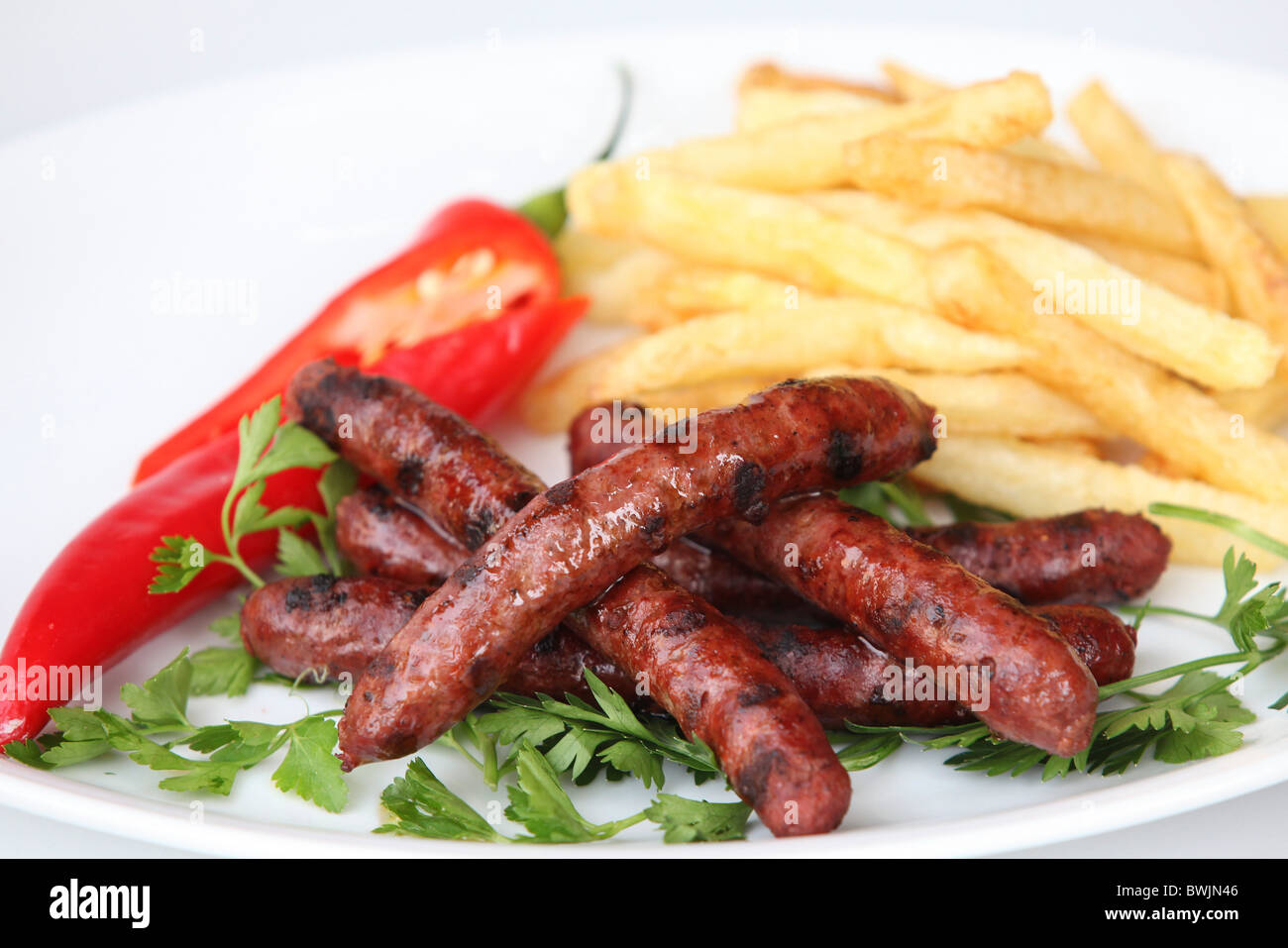 Char gegrillt Merguez Würstchen mit Pommes frites Stockfoto