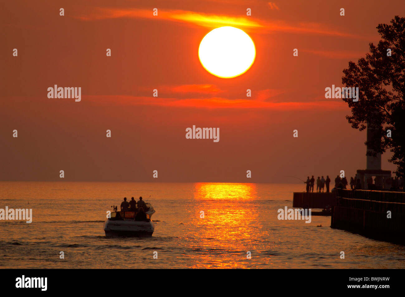 Seeufer shore Boot Person Silhouetten Landschaft Landschaft Sonne Reflexionen solar Kugel Feuer Kugel Kugel Kugel Stockfoto
