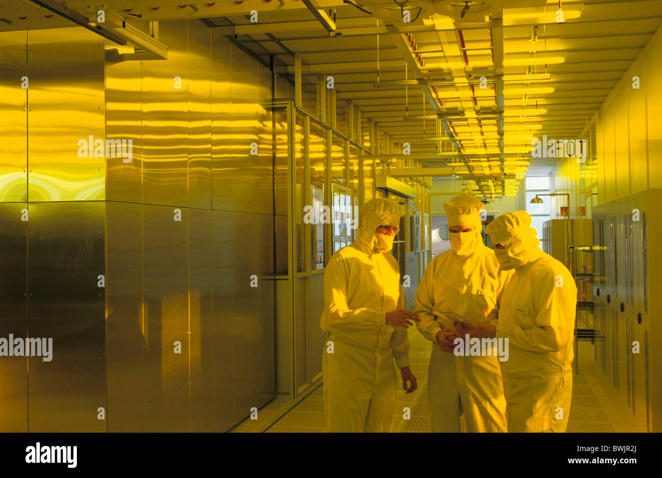 Europa, Deutschland, Sachsen, Dresden, Infineon Technologies, drei Mitarbeiter in Schutzkleidung sprechen in der Reinraumklasse Stockfoto