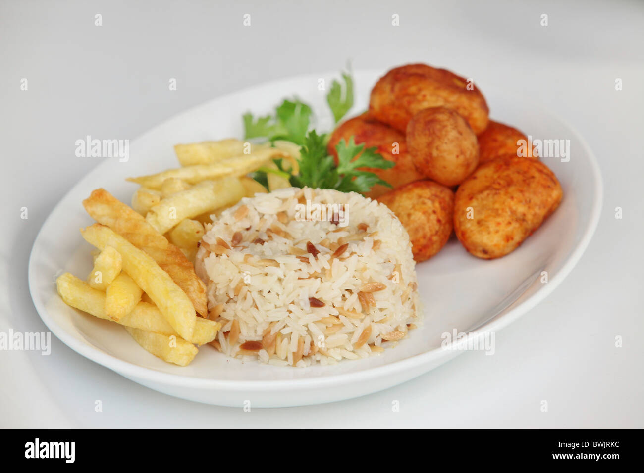 Eine Platte von Kohlenhydraten mit Ofenkartoffel Reis und Pommes frites Stockfoto